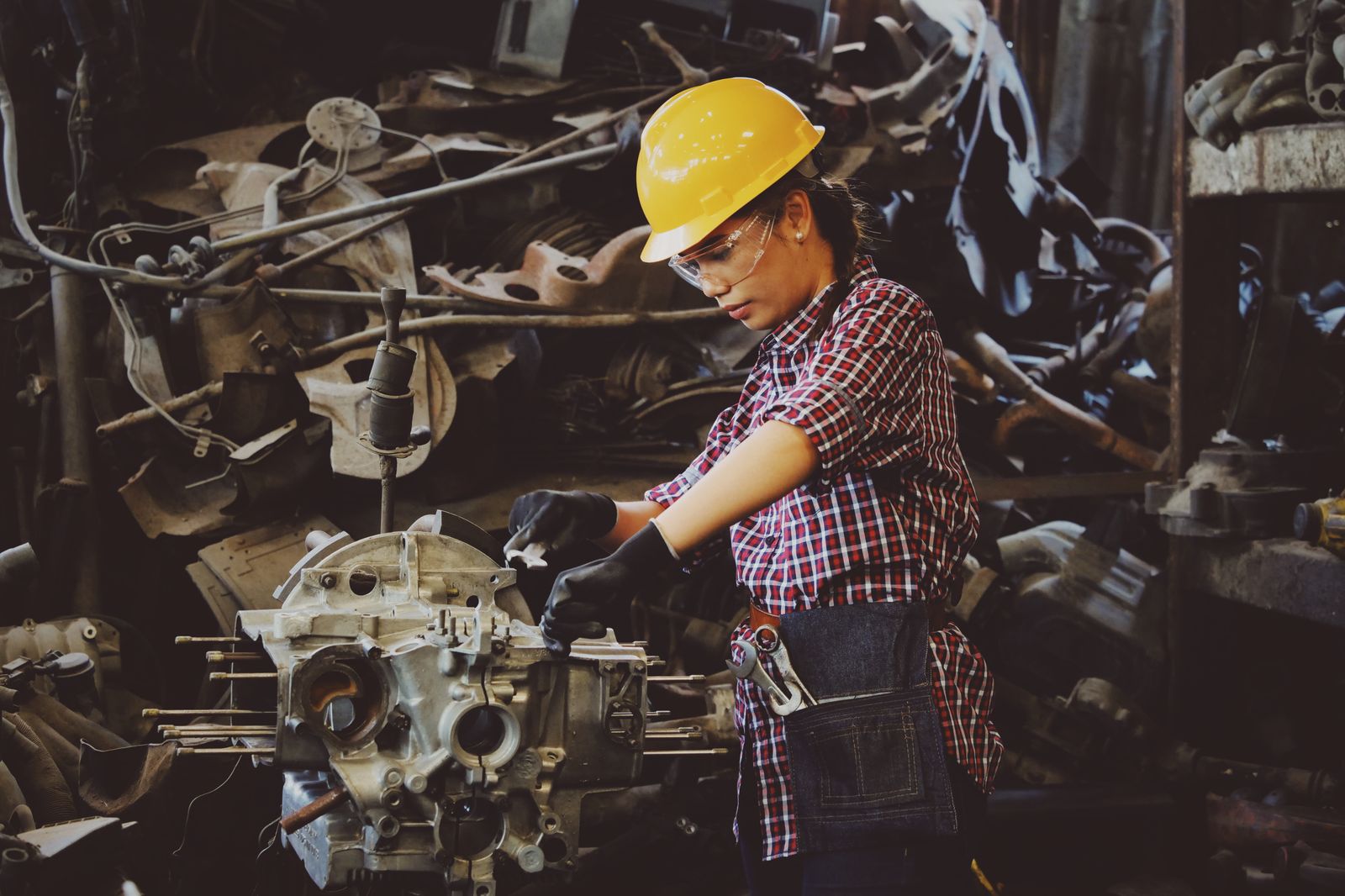 A technician in a hard hat working on industrial equipment