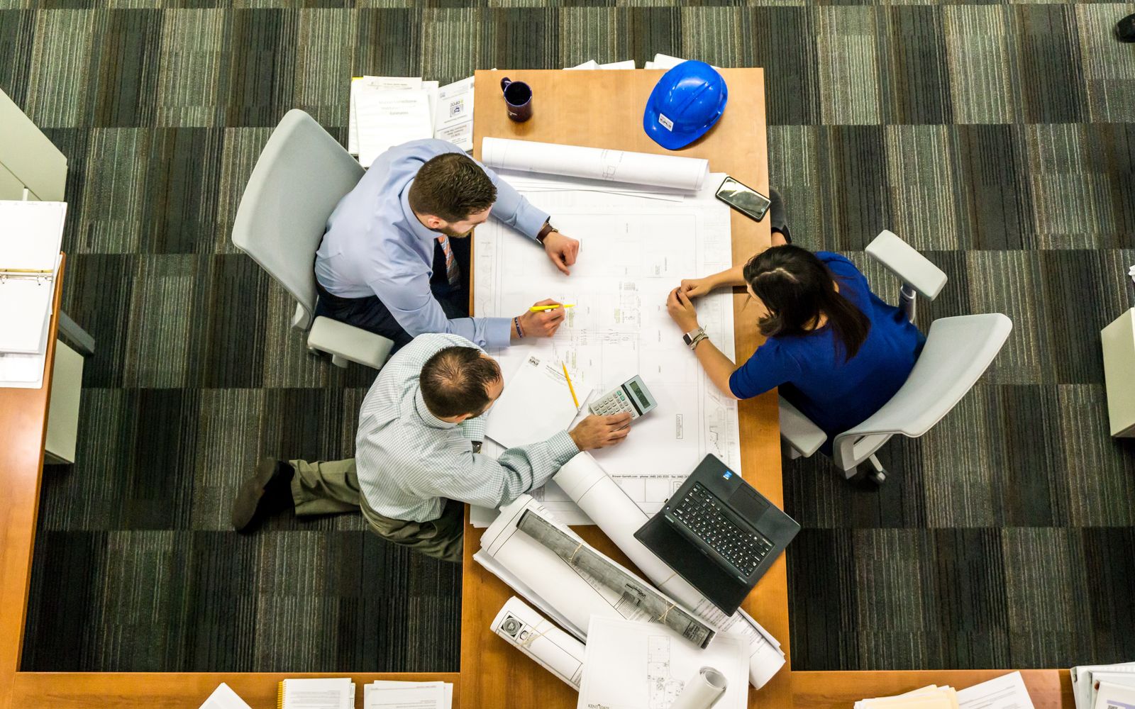Engineers reviewing drawings around a table