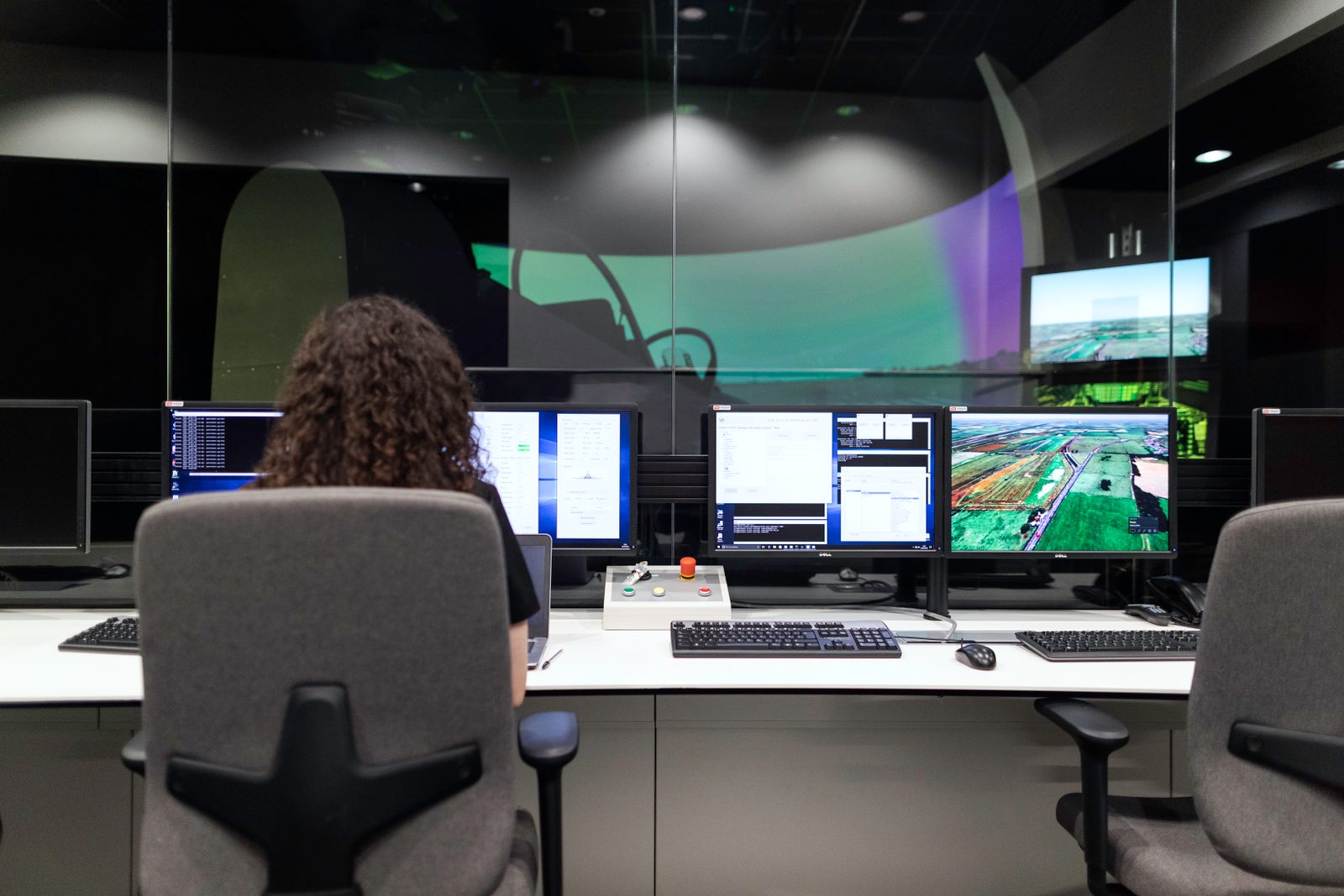 An operator at a bank of industrial control screens