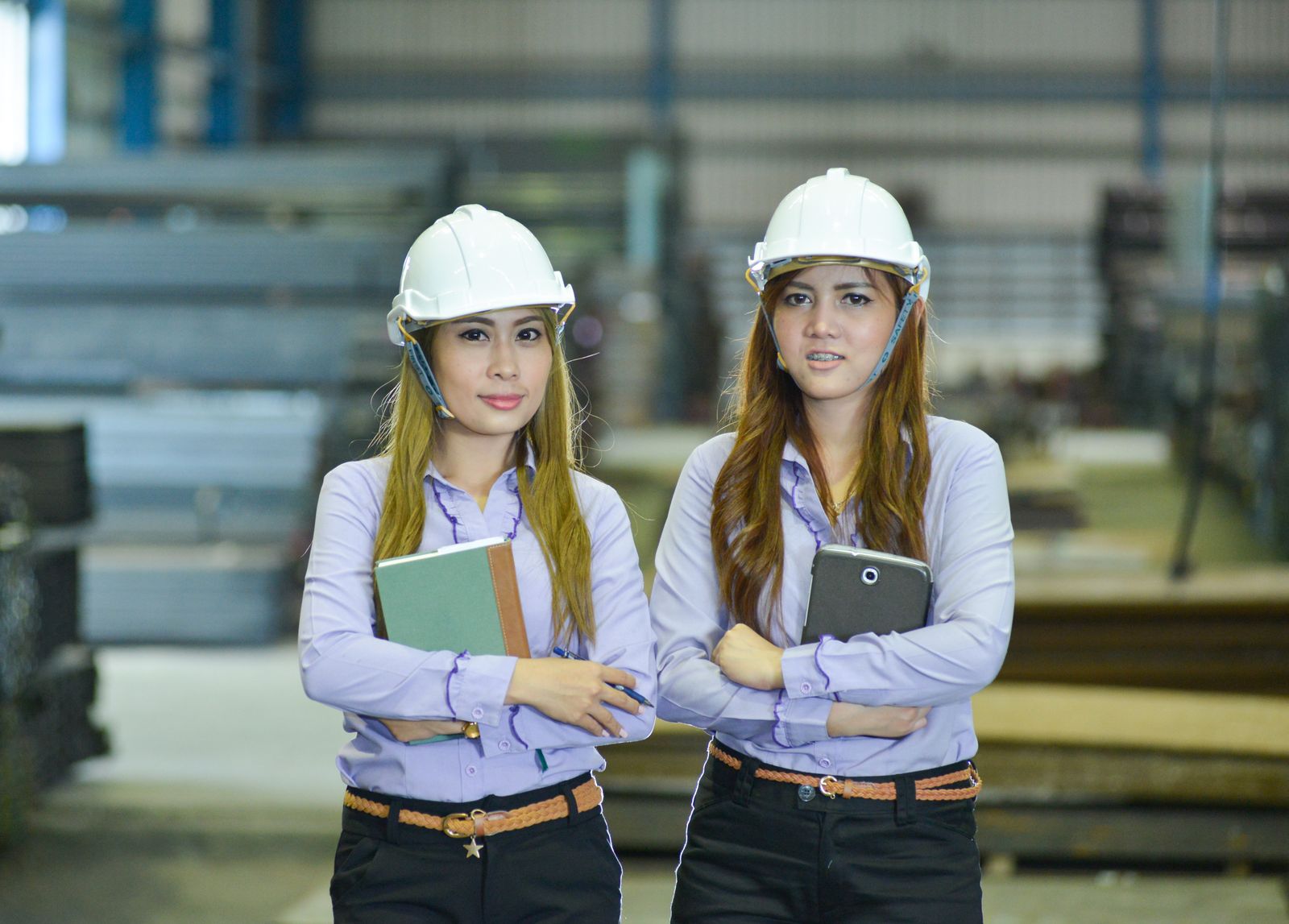 Two people in hard hats inside an industrial building